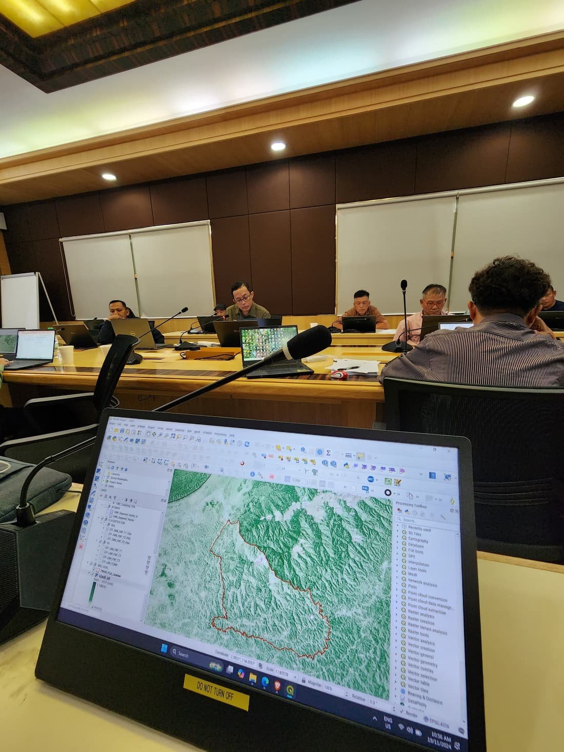 A project team reviewing a SastenaMonitor dashboard on screen