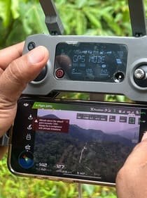 Drone controller showing a live aerial view during a UAV survey of the forest.