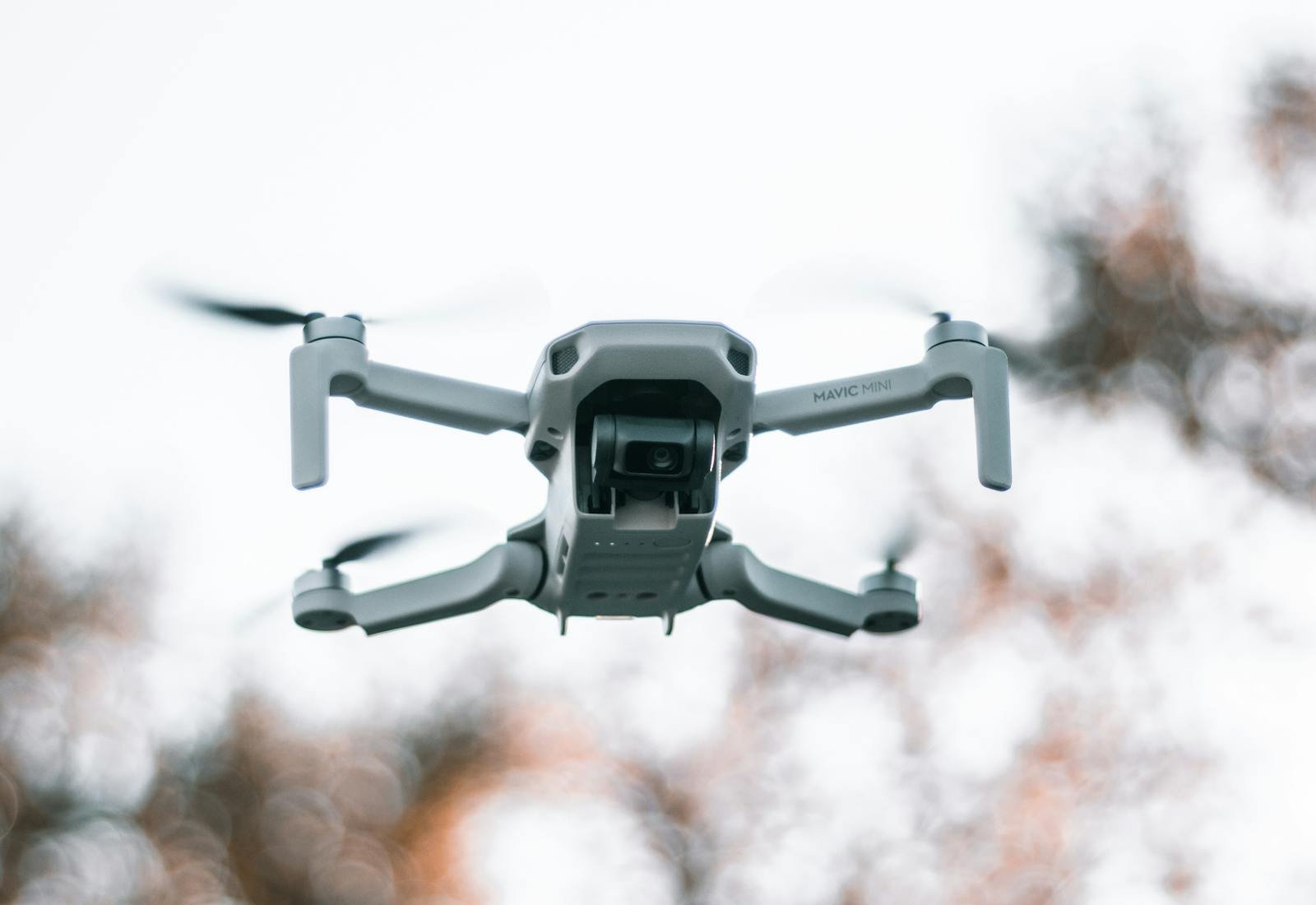 A monitoring drone in flight above a forest canopy